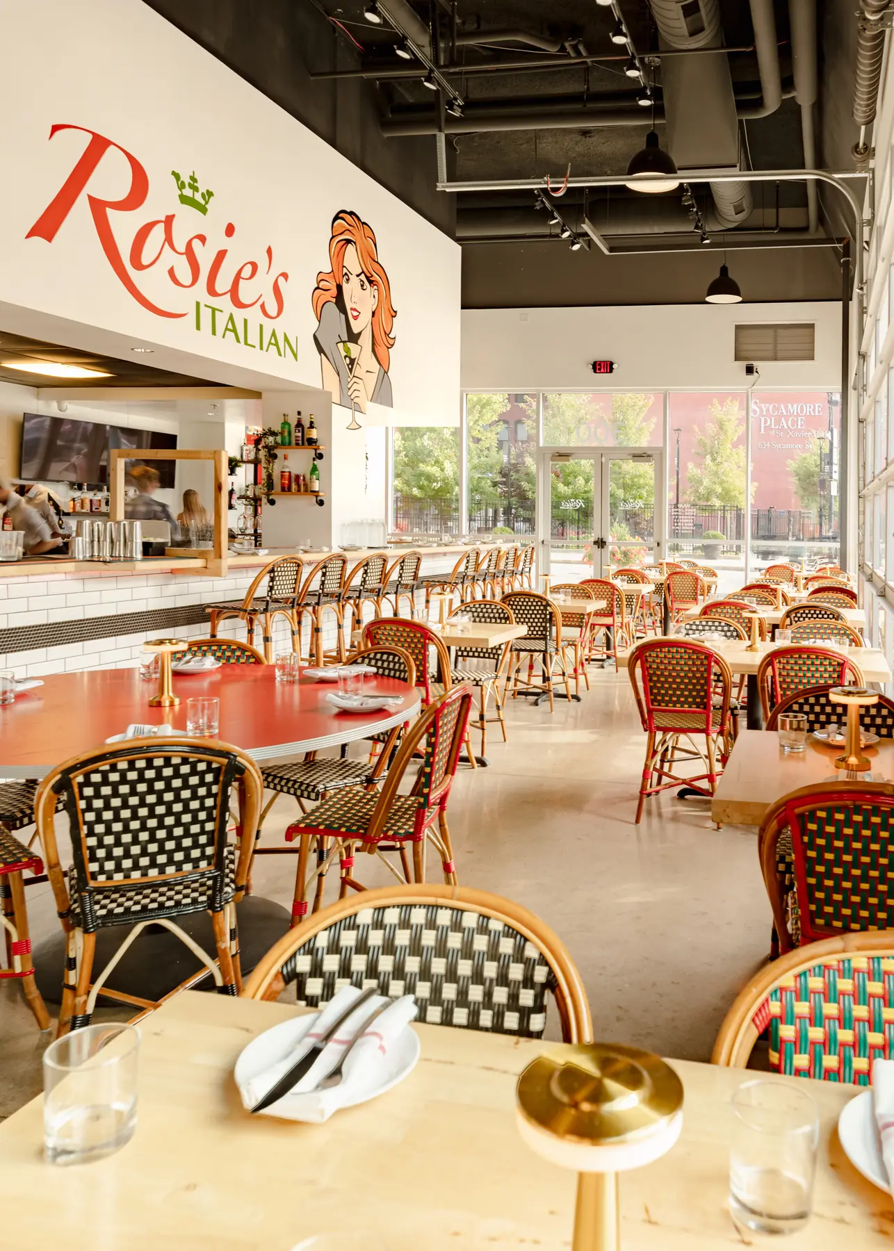 The main dining room at Rosie's Italian in downtown Cincinnati, tables set beneath the Rosie's mural